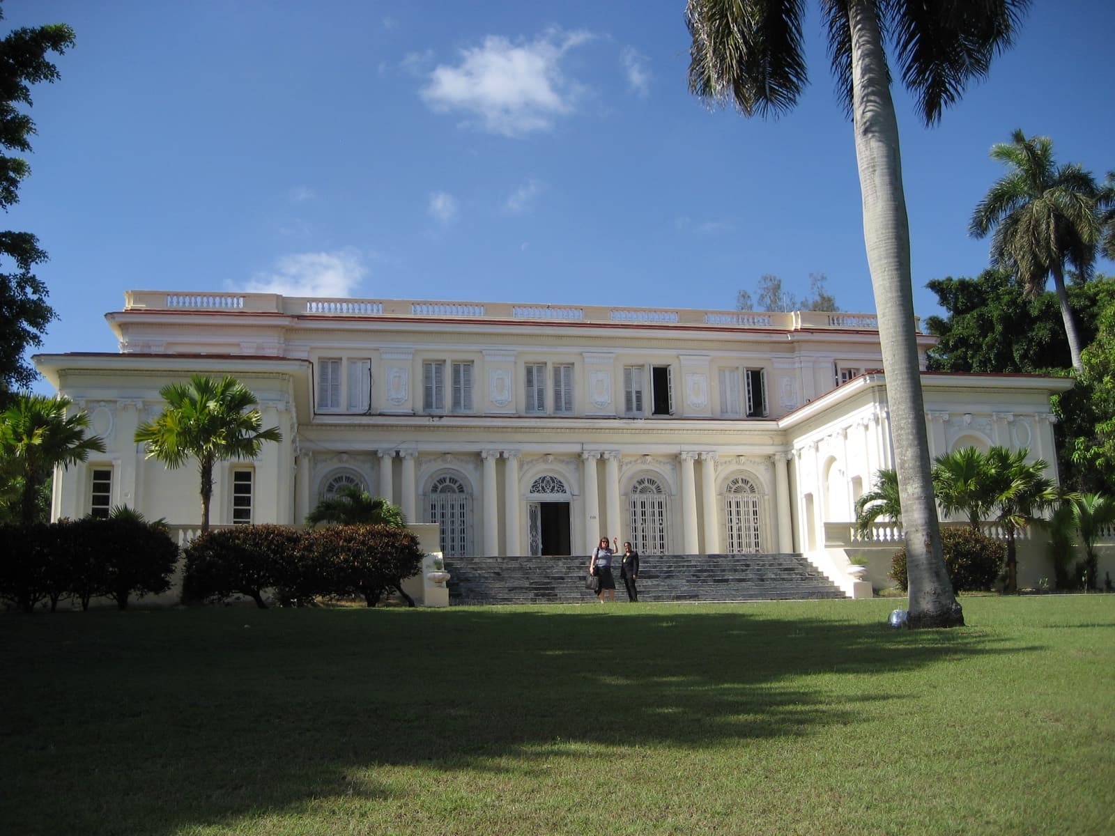 Eine herrschaftliche Kolonialvilla, gesäumt von Königspalmen, in Havanna, Kuba